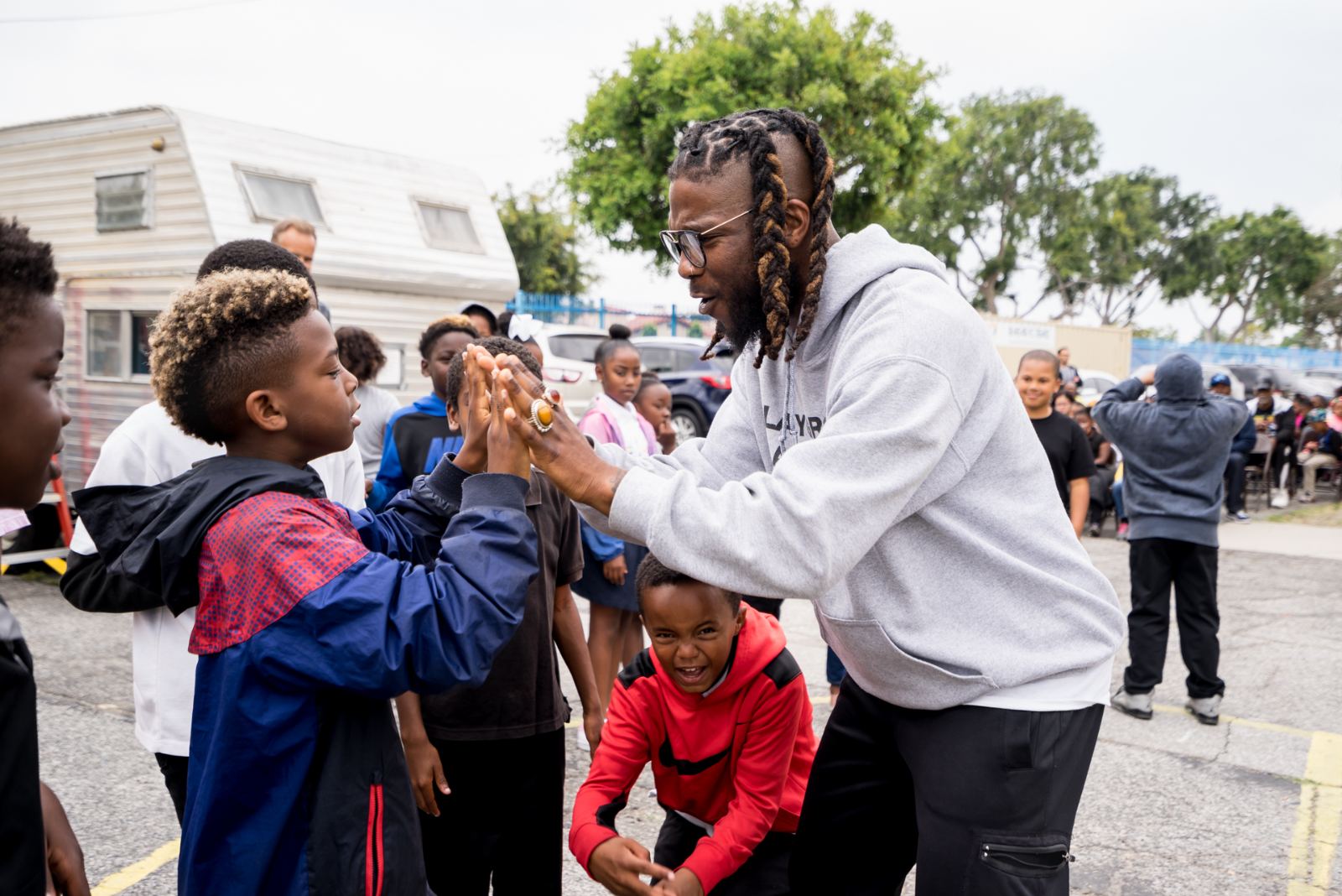 A Heidi Duckler teaching artist high-fives students at Warren Lane Elementary